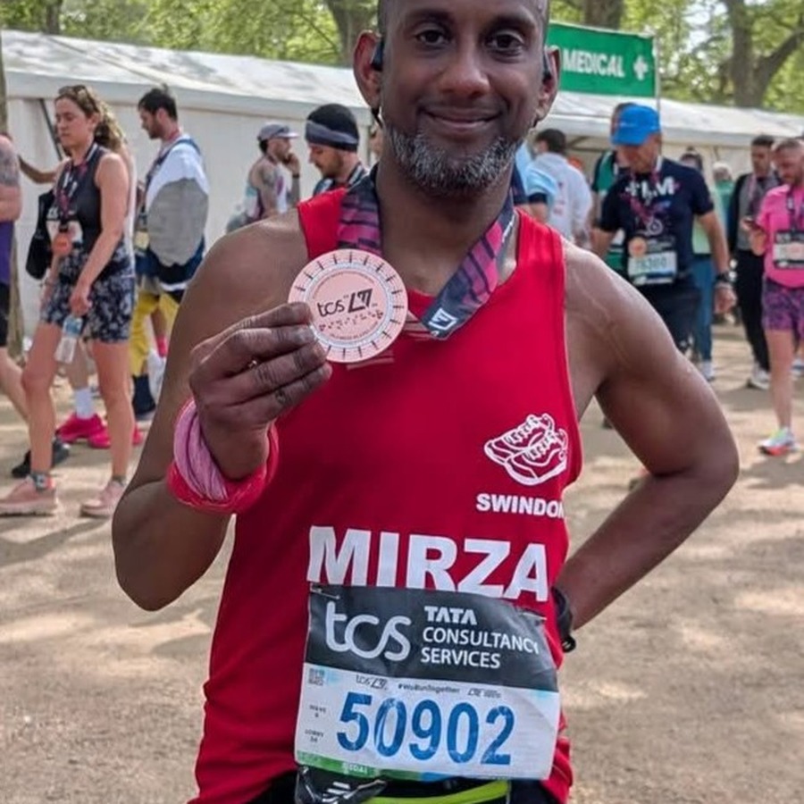 Mirza Dulull holding his medal at the London Marathon finish line.